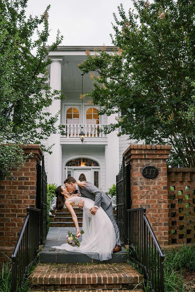 The Bride and the groom kissing on the brook steps in front of The Matthews house